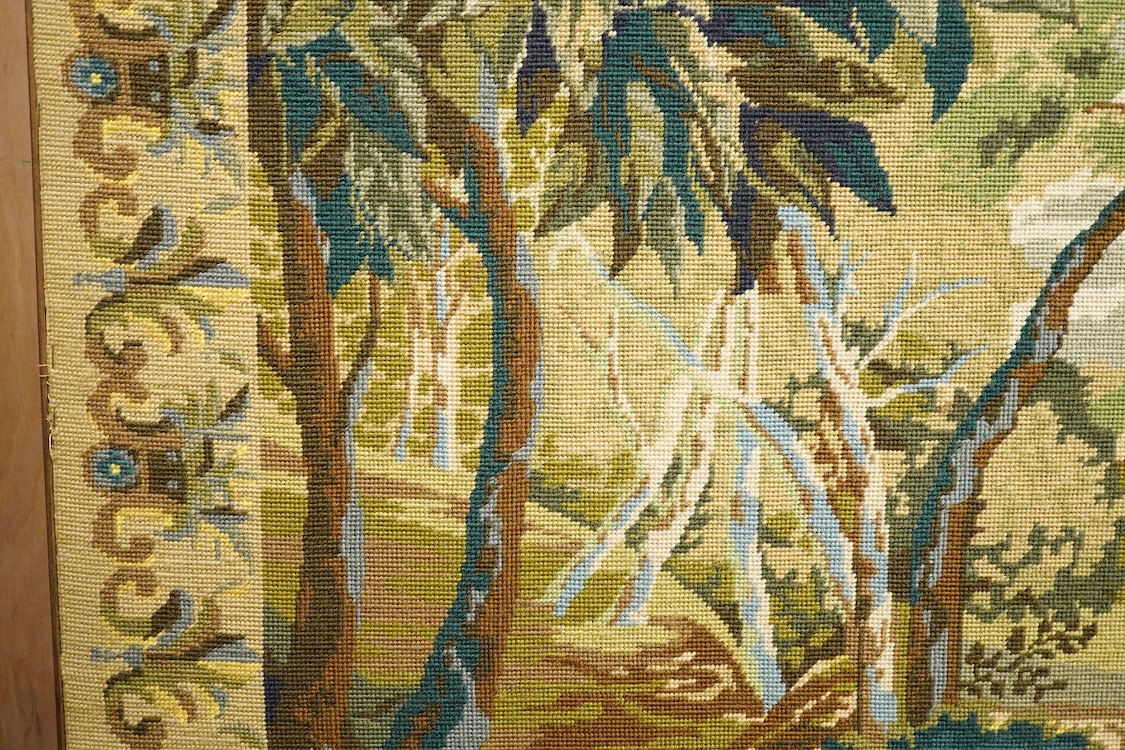 A large framed gross point wool work panel, designed in a verdure foliate palette as a classical French landscape. 161cm wide x 132 cm high.